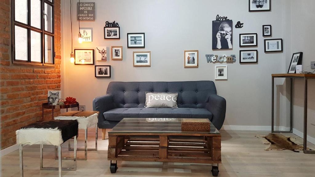 a living room with a blue couch and a table at Apartamento Salamanca in Madrid