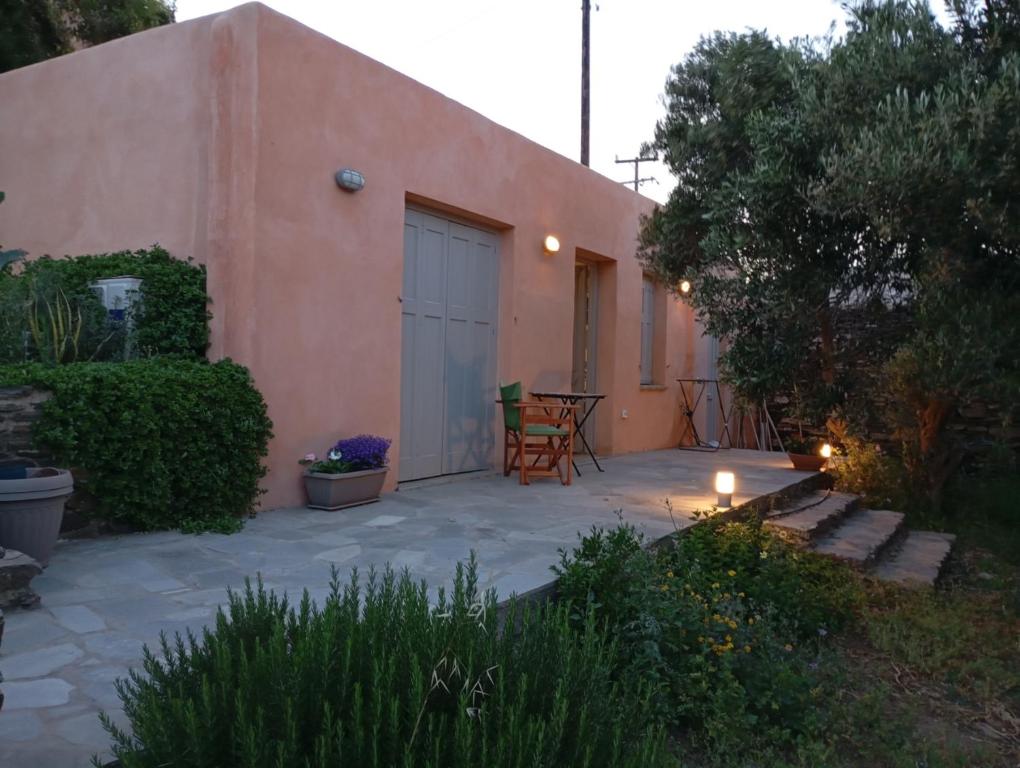 a patio in front of a house with a table and chairs at Blue Agave in Agios Sostis