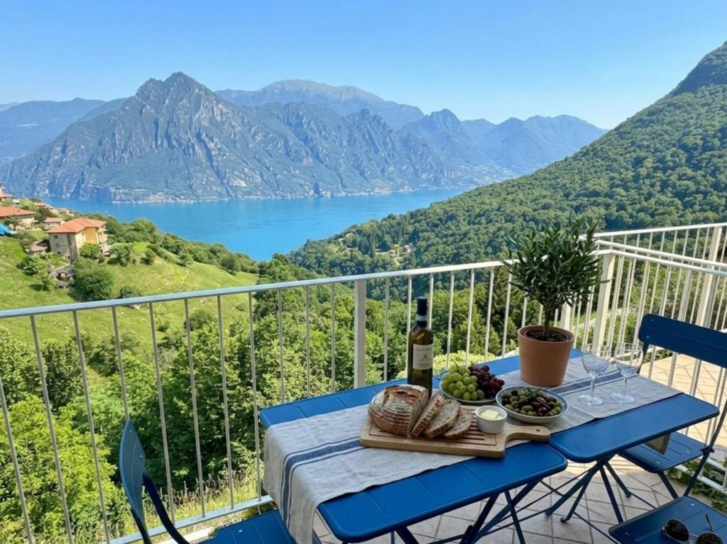 a table with a bottle of wine and a plate of food at Lake Iseo View Retreat - Quiet & Nature in Fonteno