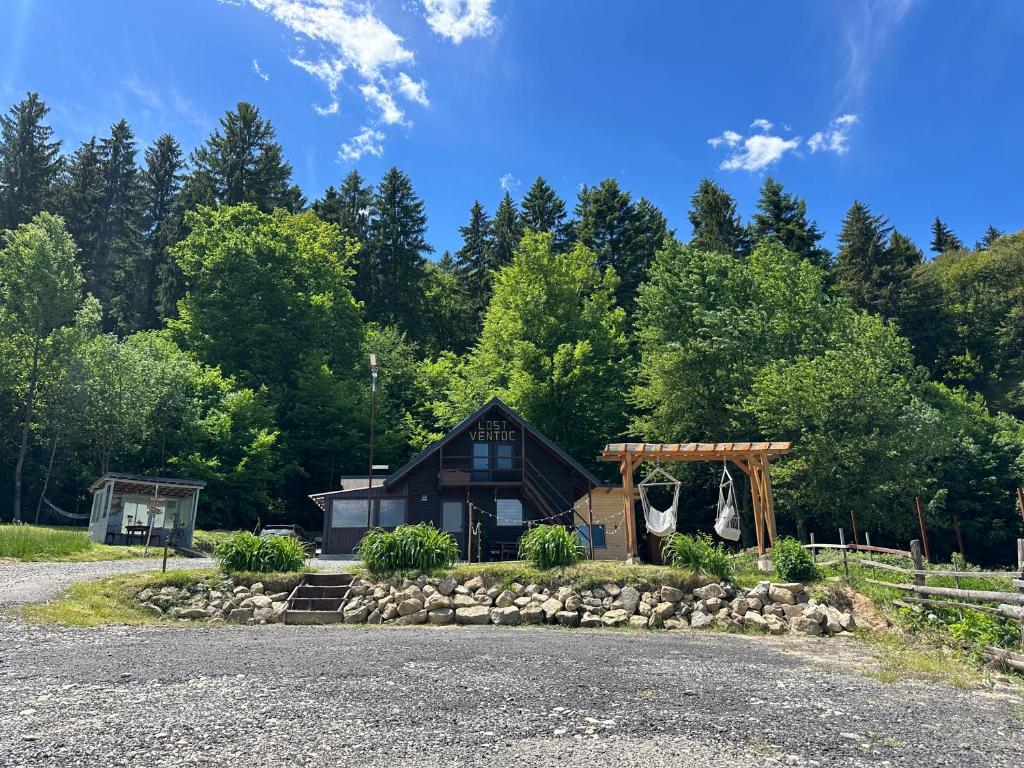 a house with a gazebo and a gravel driveway at Cabana LoSt Ventoc in Vulcan