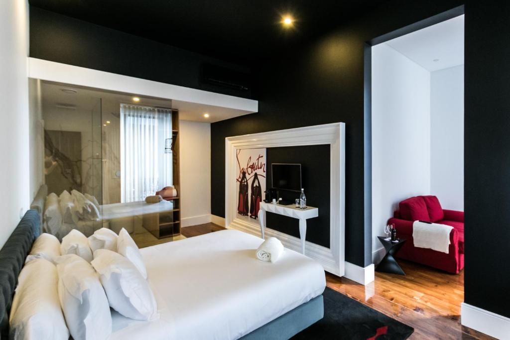 um quarto com uma cama branca e um sofá vermelho em RM The Experience - Small Portuguese Hotels em Setúbal