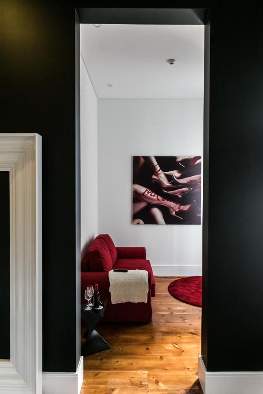 a living room with a red couch and a mirror at RM The Experience - Small Portuguese Hotels in Setúbal