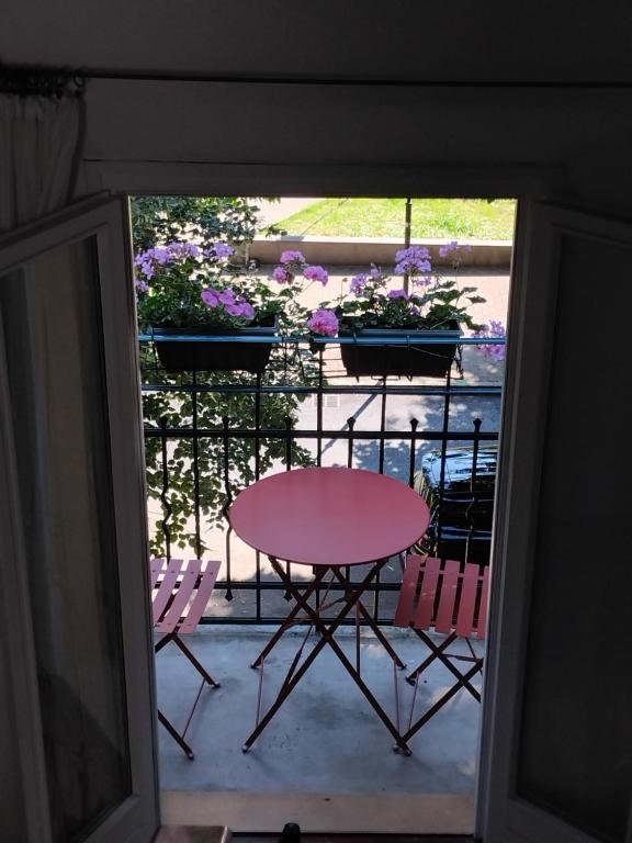 a table and chairs on a balcony with flowers at Sogni in soffitta in Casalecchio di Reno