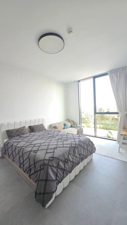 a bedroom with a bed and a large window at Kuro Homes in Sharjah