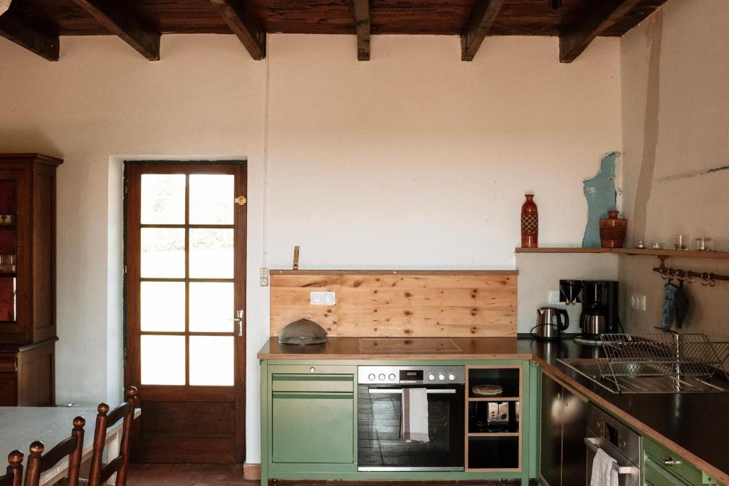 a kitchen with a green oven and a sink at Saint Germain - Logis de Beaulieu in Poullignac