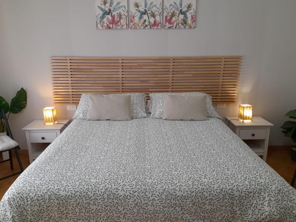 a bedroom with a large bed with two lights on it at BGM apartment Rho Fiera Milan in Cesate