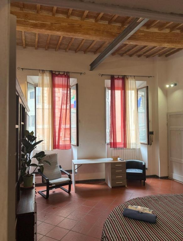 a living room with red windows and a couch at Casa in Corso, Colle Val d'Elsa in Colle di Val d'Elsa