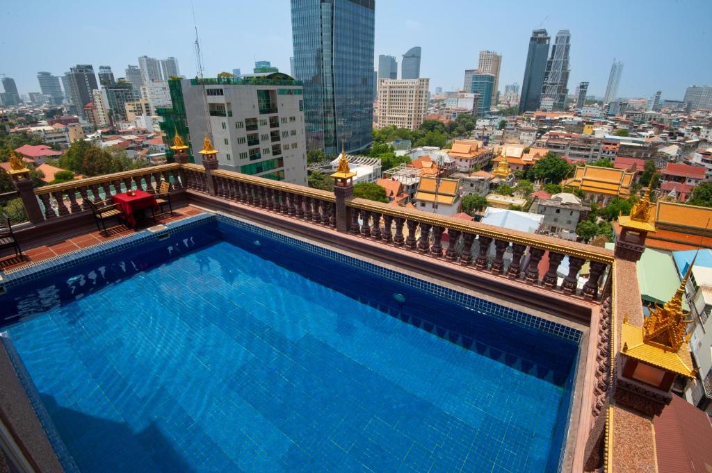 a swimming pool on top of a building with a city at Okay Palace Hotel in Phnom Penh