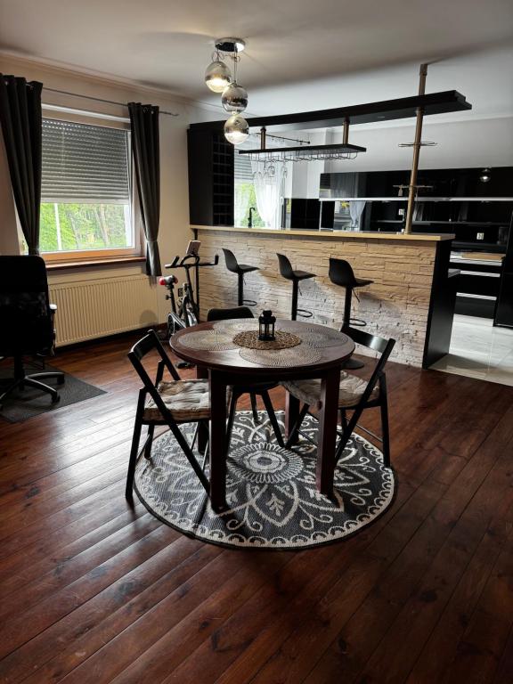 a living room with a table and chairs and a kitchen at Studio na MIARĘ in Jarocin