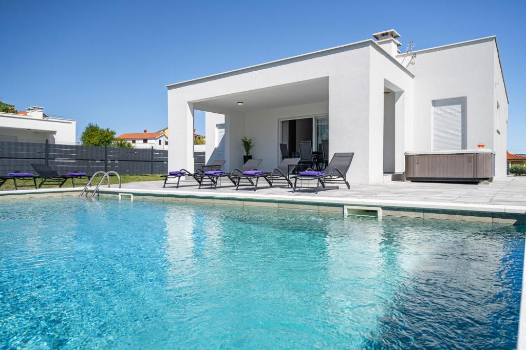 a villa with a swimming pool in front of a house at Villa Vallis in Nedeščina