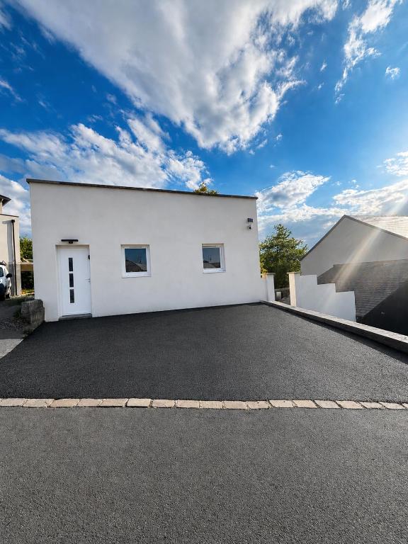 a large white garage with a large driveway at Maison convivial in Vireux-Wallerand