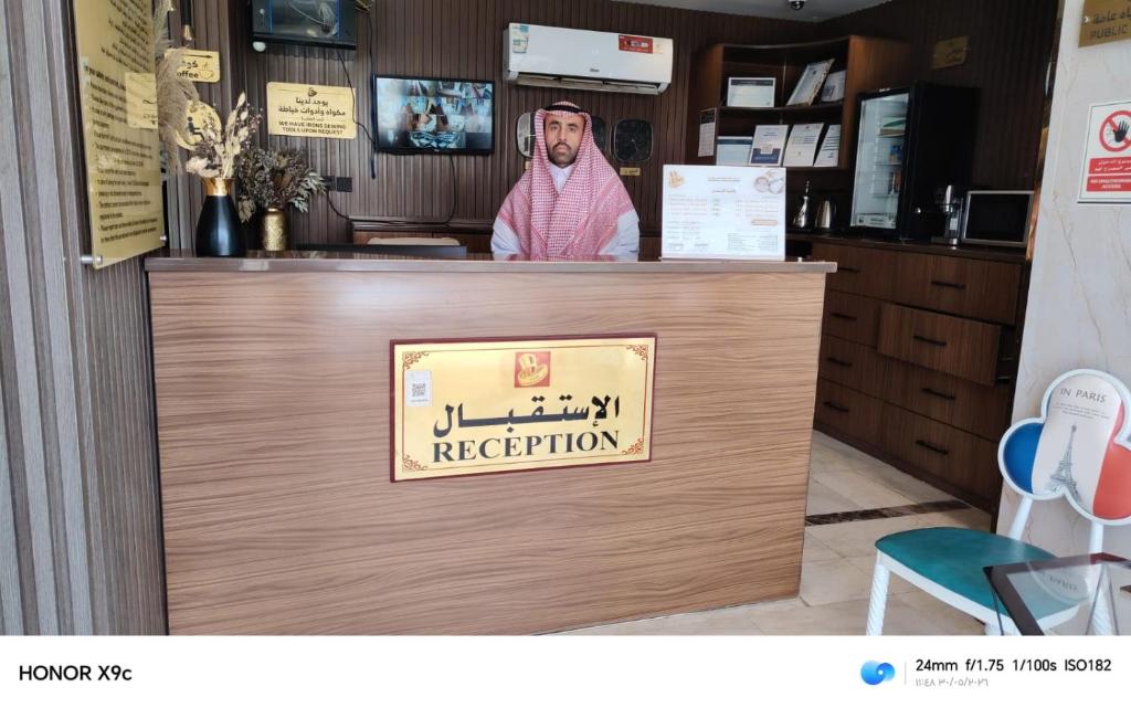 a man standing behind a counter in a restaurant at أبو بندر للشقق المخدومة in Ar Rass
