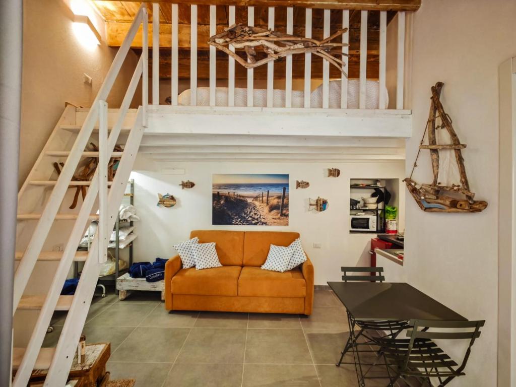 a living room with a loft bed and a couch at Casetta Ismeralda in Carloforte