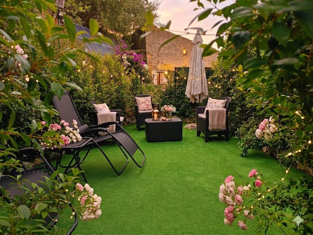 een tuin met groen gras, stoelen en bloemen bij La Pace in Savoca 