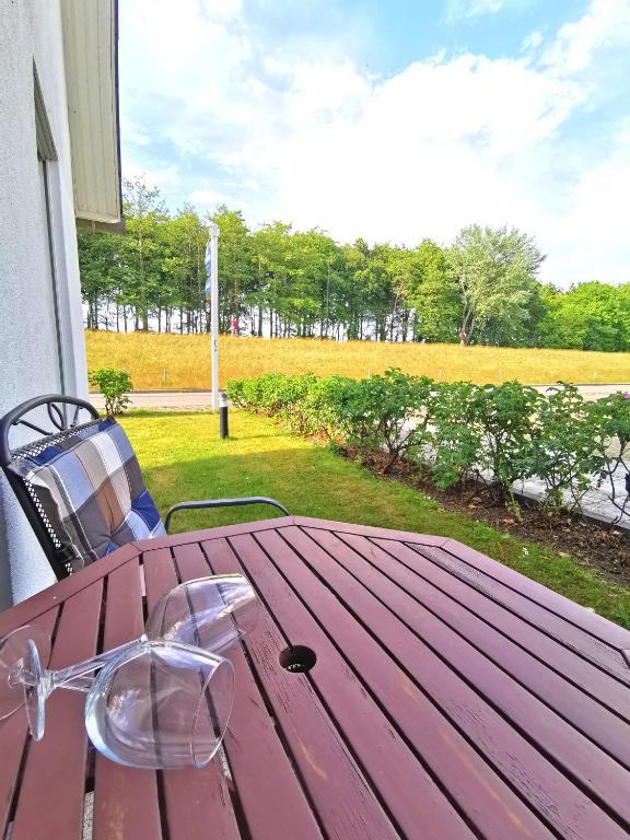a red picnic table with glasses on top of it at BERNSTEINHAUS in Zingst barrierefreie 2-Raum-Wohnung mit Terrasse - Nr 1 in Zingst