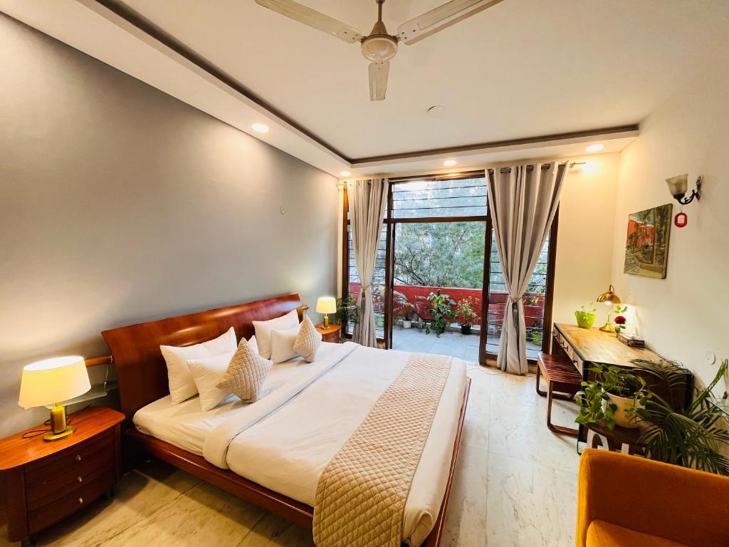 a bedroom with a bed and a desk and a window at Grove Residency Huaz Khas New Delhi - Couple Friendly in New Delhi