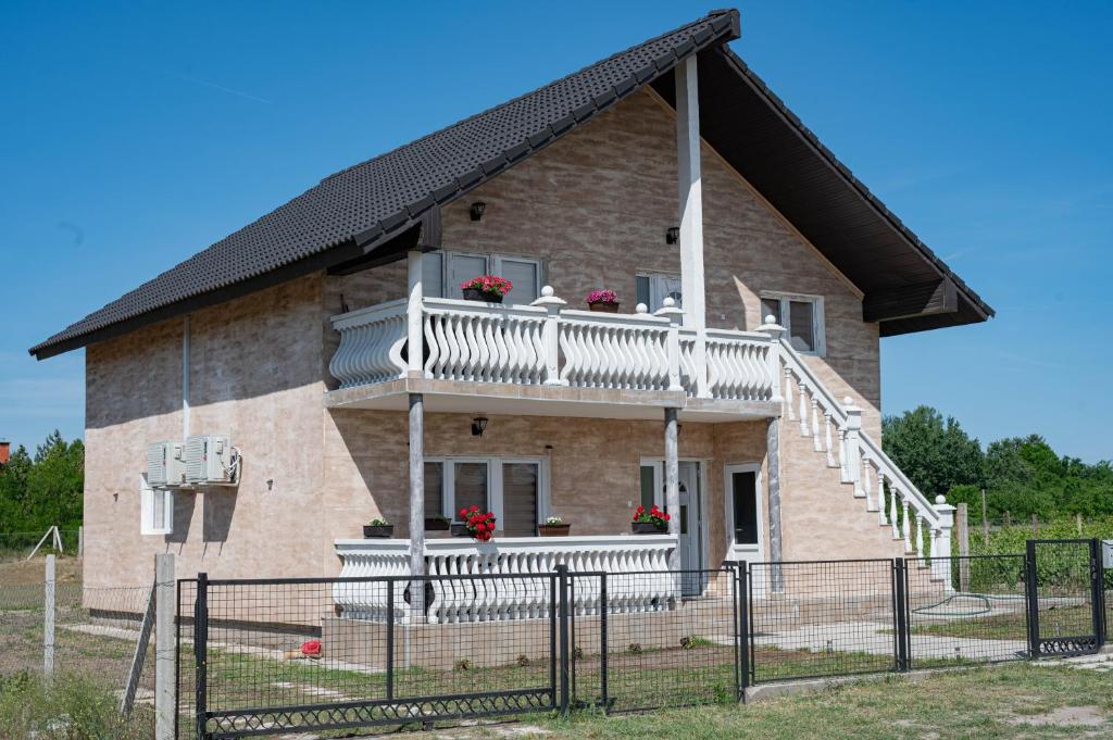 a house with a balcony with flowers on it at Apartman Sofija Palić in Palić