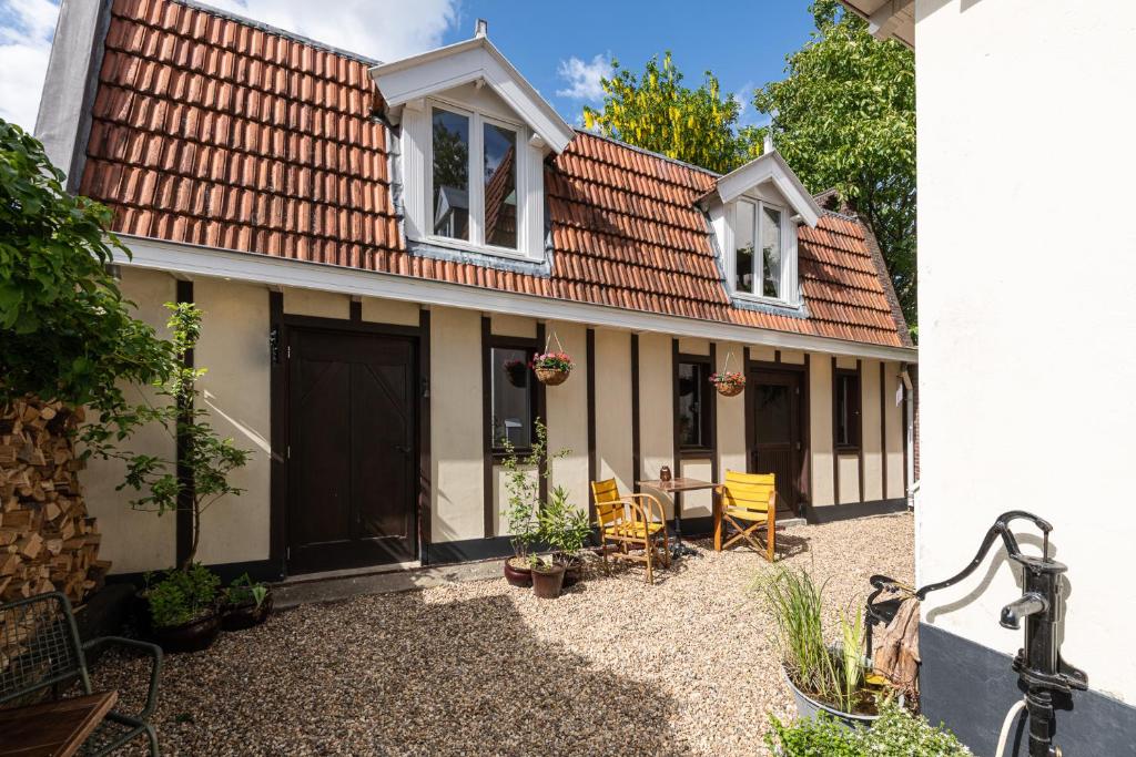 a house with a red roof and yellow chairs at Logement Welgelegen - Charming private stay with sauna near Nijmegen in Millingen aan de Rijn