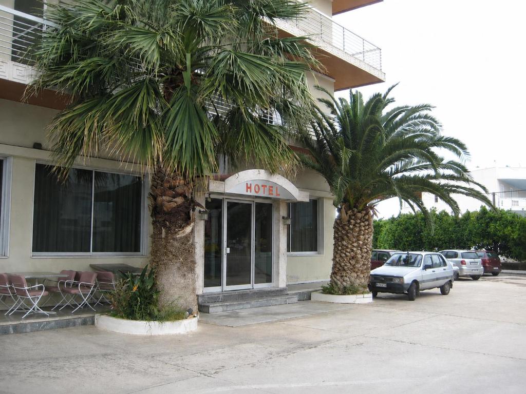 a hotel with two palm trees in front of it at HOTEL ALEXANDROS in Loutraki