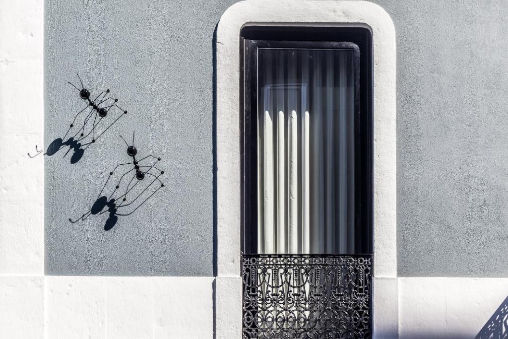 a window with three ants on the side of a building at RM The Experience - Small Portuguese Hotels in Setúbal