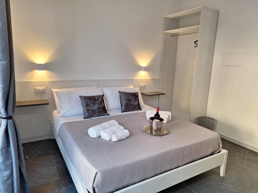 a bed with towels and a bottle of wine on it at Vanity Suite in Cefalù