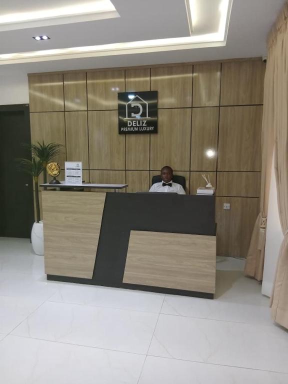 a man sitting at a reception desk in a lobby at JKB PREMIUM lUXURY in Lekki