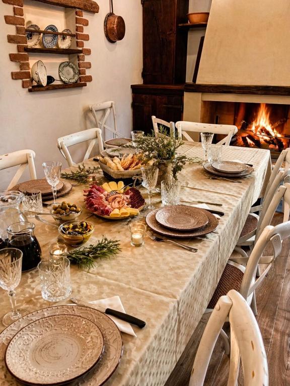 a table with plates and food on it with a fireplace at S'Ispera B&B, Home Restaurant, Autentiche Esperienze Sarde in Fonni