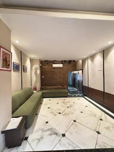 a living room with a green couch and a tile floor at Status Business Hotel - Naveen Market in Kānpur