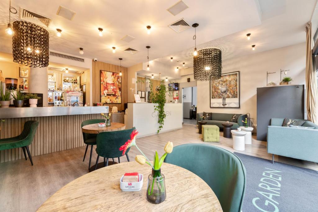 a restaurant with tables and chairs and a bar at Garden Hotel in Zagreb