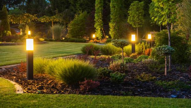 a garden with three lights in the grass at night at De Villione Guesthouses in Bultfontein