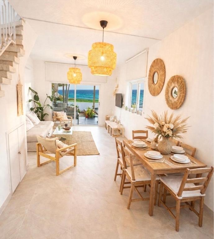 a living room with a wooden table and chairs at Cozy beach house in Perivolia
