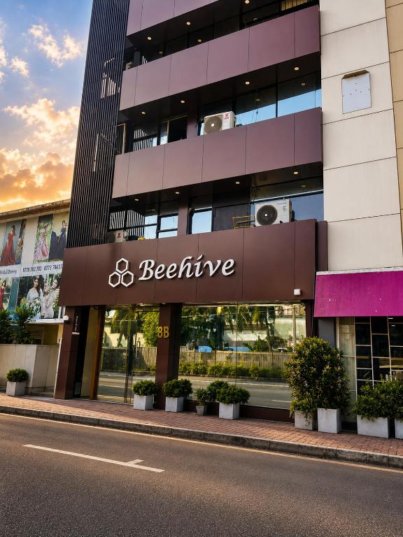 a building with a beeline sign on the side of a street at The Beehive in Bambalapitiya