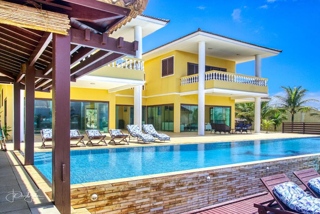 a villa with a swimming pool and a house at Casa da Estrela in Barra do Cunhau