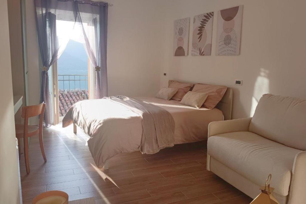 a bedroom with a bed and a couch and a window at Torre del Borgo - Centro Storico di Accettura in Accettura
