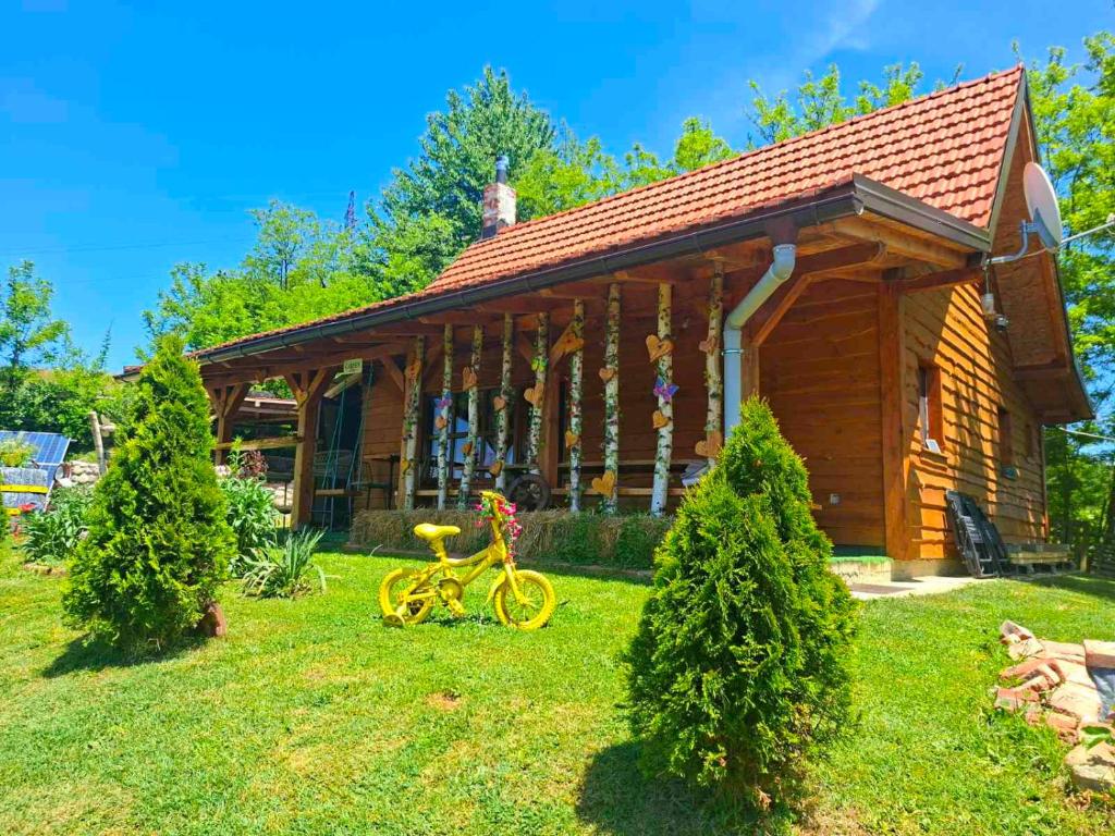 a small wooden house with a bike in the yard at Kuca za odmor in Vitez