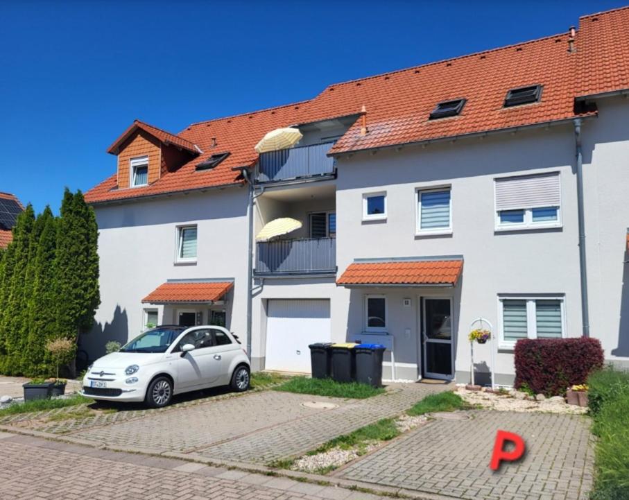 a white house with a car parked in front of it at Ferienwohnung Erdmännchen in Erfurt