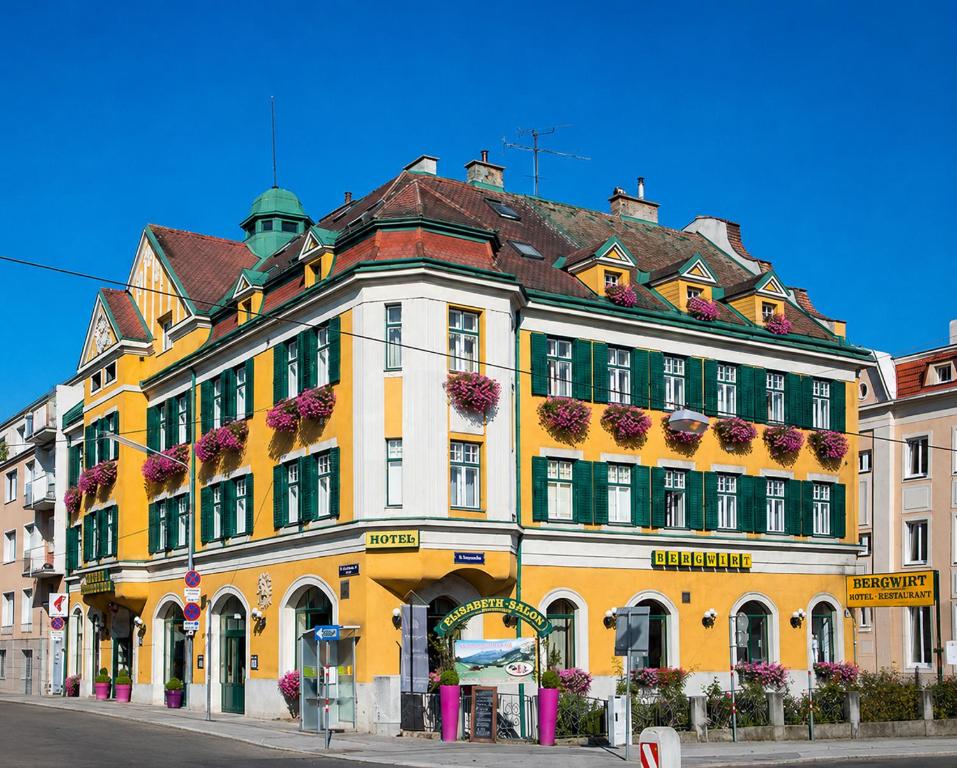 a yellow and white building on the side of a street at Hotel Bergwirt Schönbrunn in Vienna