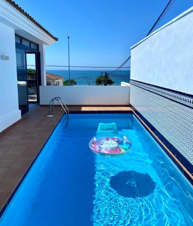 a swimming pool with a toy in front of a house at Chalet Playa Mazagon in Mazagón