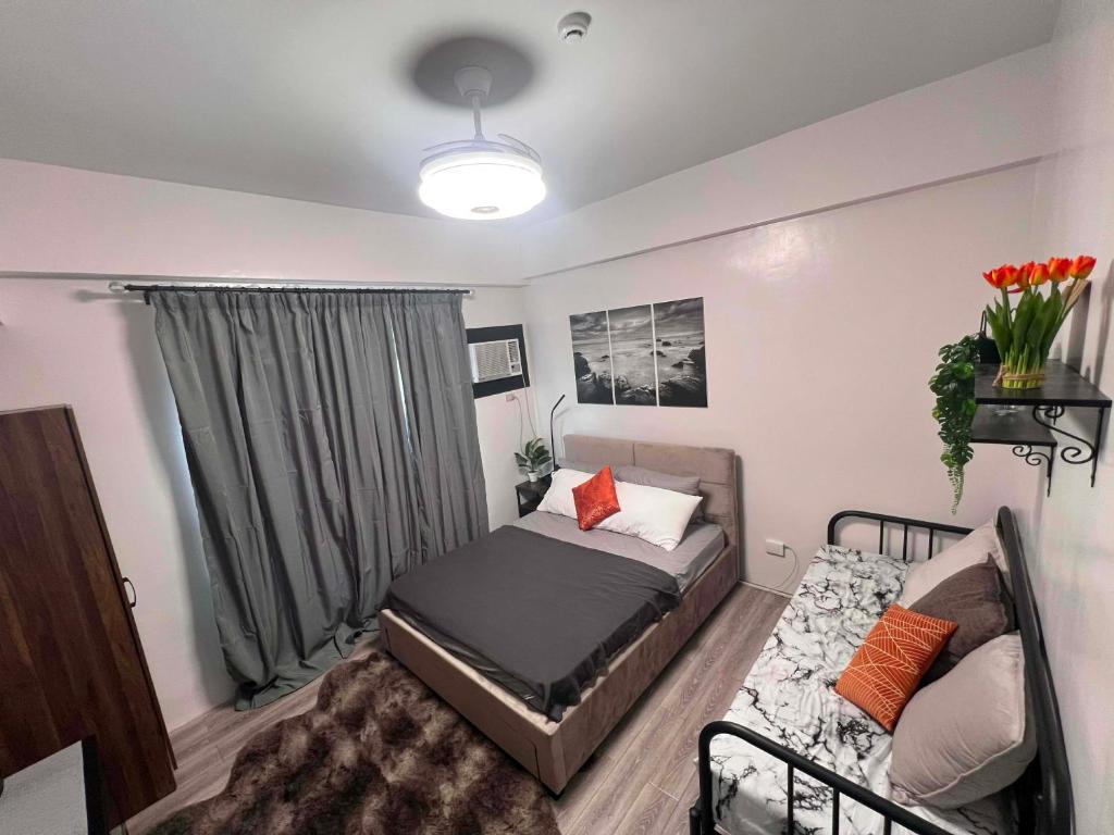 a small bedroom with a bed and a couch at Unit 207C Amani Grand Resort & Residences in Pusok