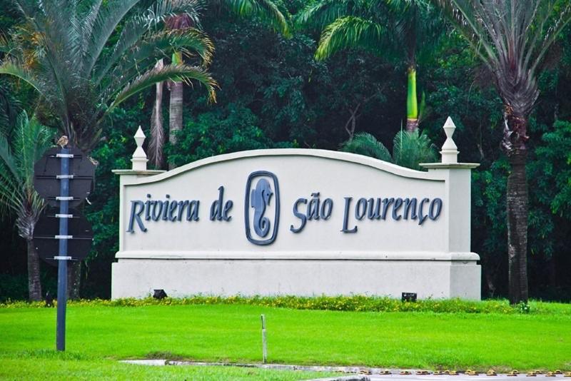 a sign for a store in a park at Flat lindo a 120 metros da praia de Riviera de São Lourenço até 4 pessoas in Bertioga