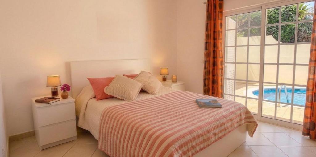 a bedroom with a bed with a view of a pool at Casa Nuno in Lagoa