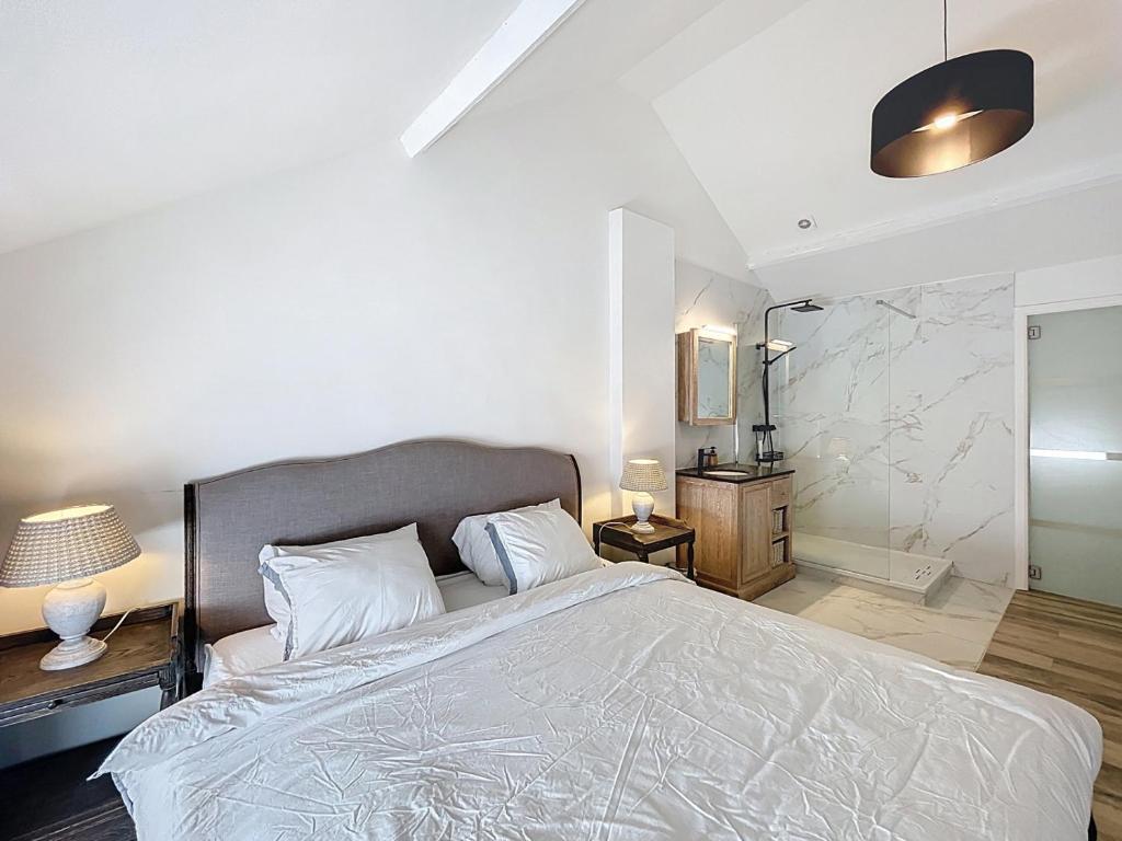 a bedroom with a large bed with white sheets at Charmante maison in Namur