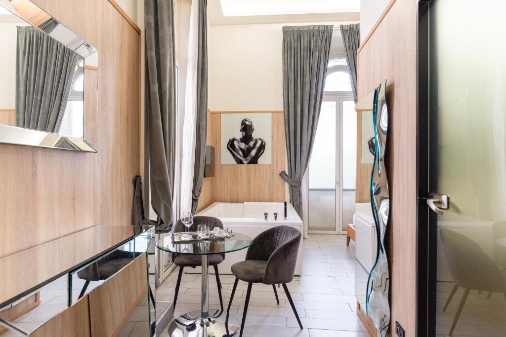 a bathroom with a glass table and a bath tub at Kore Luxury Suite e Spa in Naples