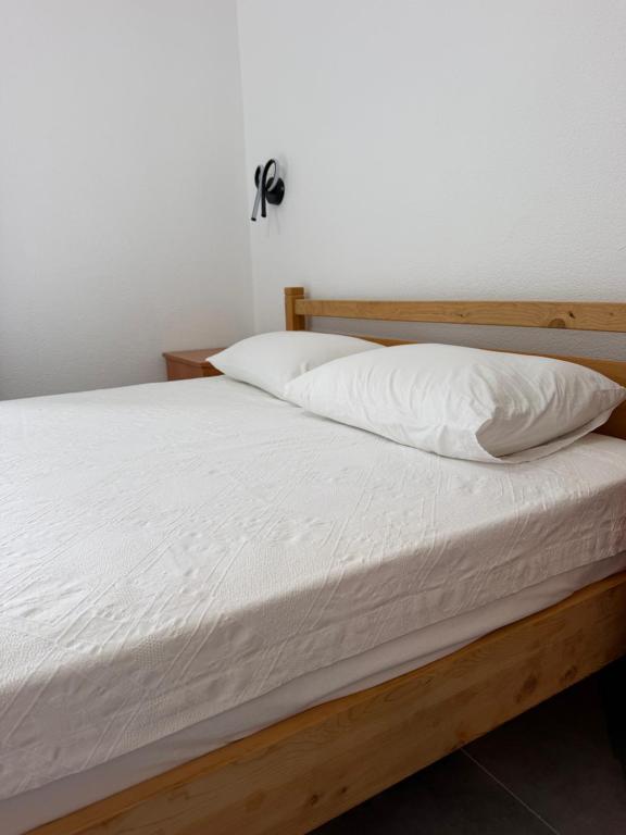 a bed with white sheets and pillows on it at Armeda Restoran ve Pansiyon in Datca