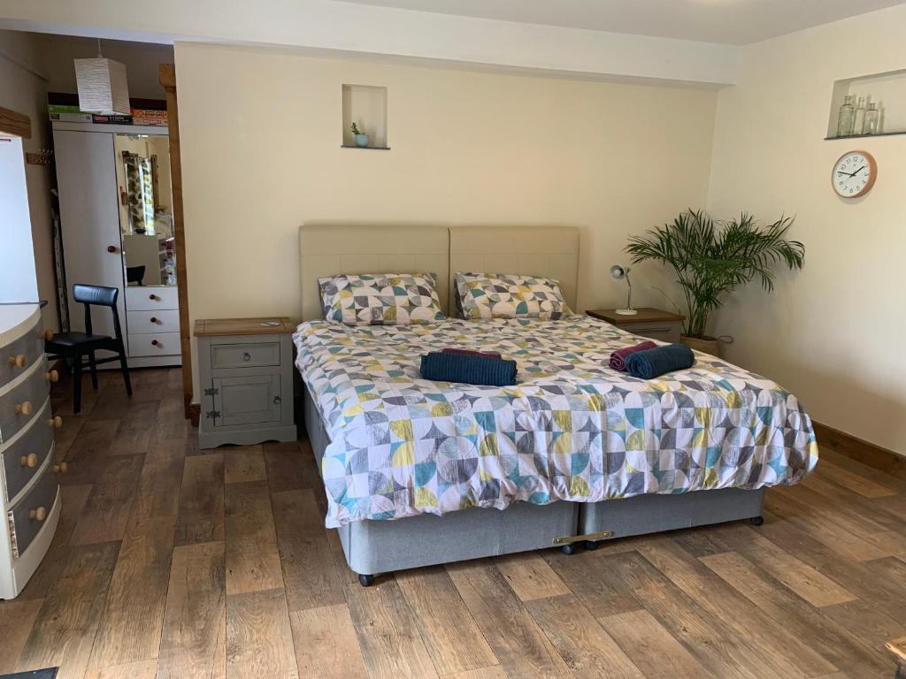 a bedroom with a bed and a table with a plant at The Shippon at RoseHip in Launceston