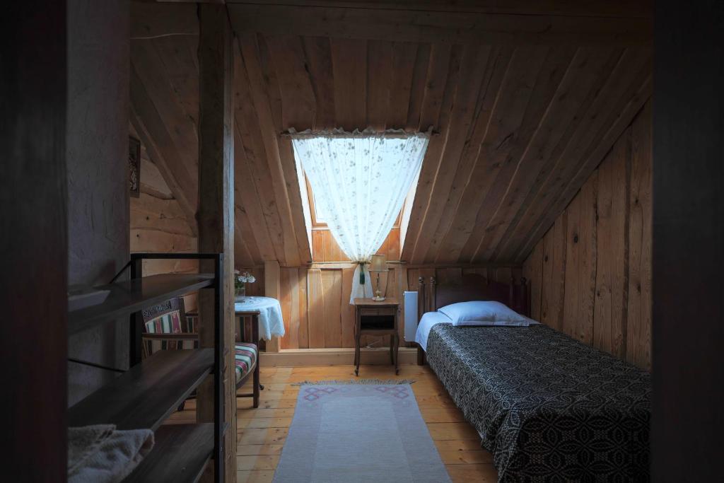 a small bedroom with a bed and a window at Kaimo sodyba Senas rublis in Pesčiai