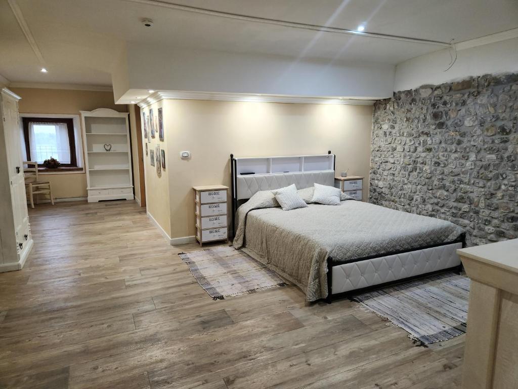a bedroom with a bed and a stone wall at Il Pozzo dei Desideri Vintage in Spilimbergo