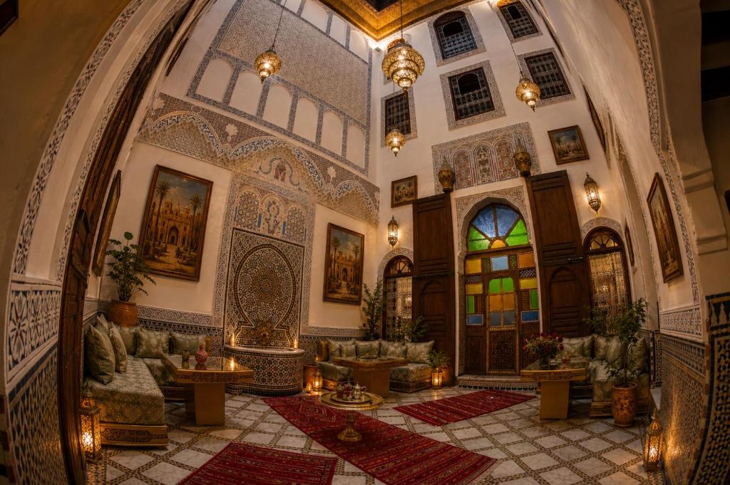an ornate lobby with a large room with tables and chairs at Riad T-A-J Fès Crown in Fez