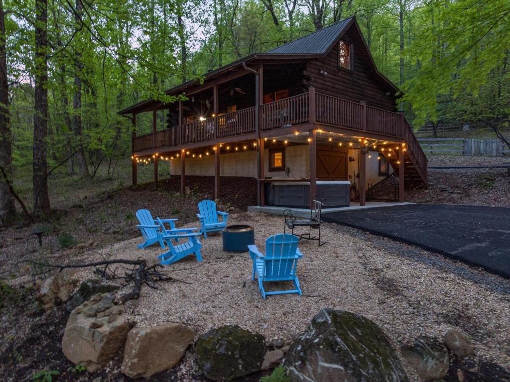 a log cabin with blue chairs and a house at Bear Tracks Cottage in Nellysford