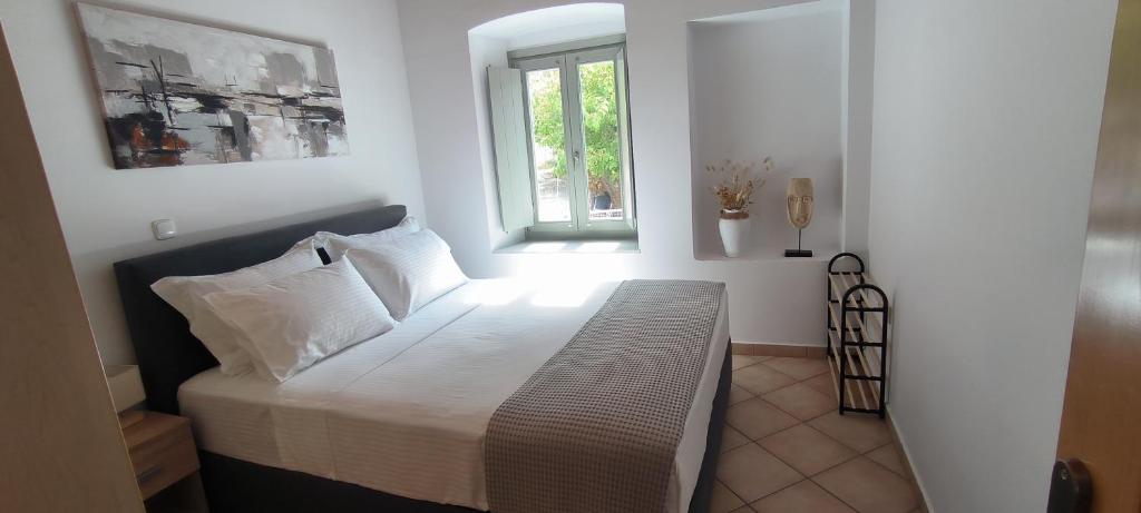 a bedroom with a bed with a window at Vrisi House in Kiparission